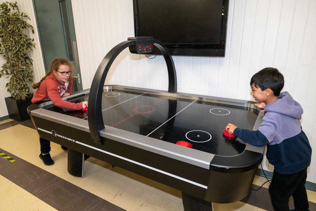 photo of 2 young people enjoying a game of air hockey