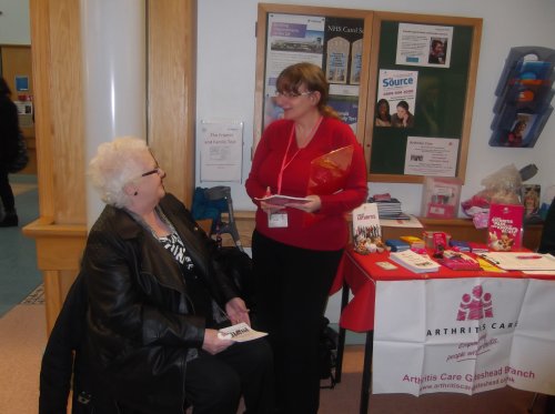 Volunteer helping an elderly woman at a drop in point