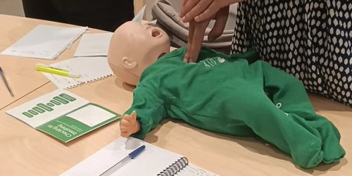 Image shows first aid being demonstrated on a dummy