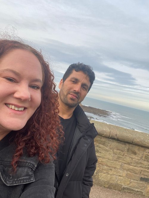 Photo of a befriender and refugee friend visiting the beach together
