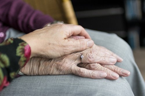 a close up image hand resting on top of another hand 