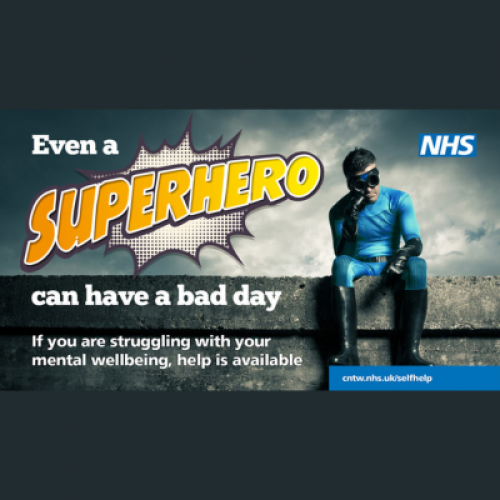 a man dress as a super hero sitting on a wall, with his chin resting on his first looking a bit glum