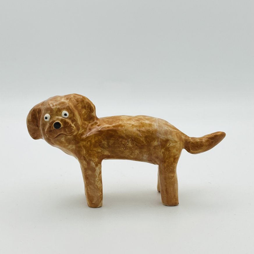 A photo of a brown ceramic dog on a white background.