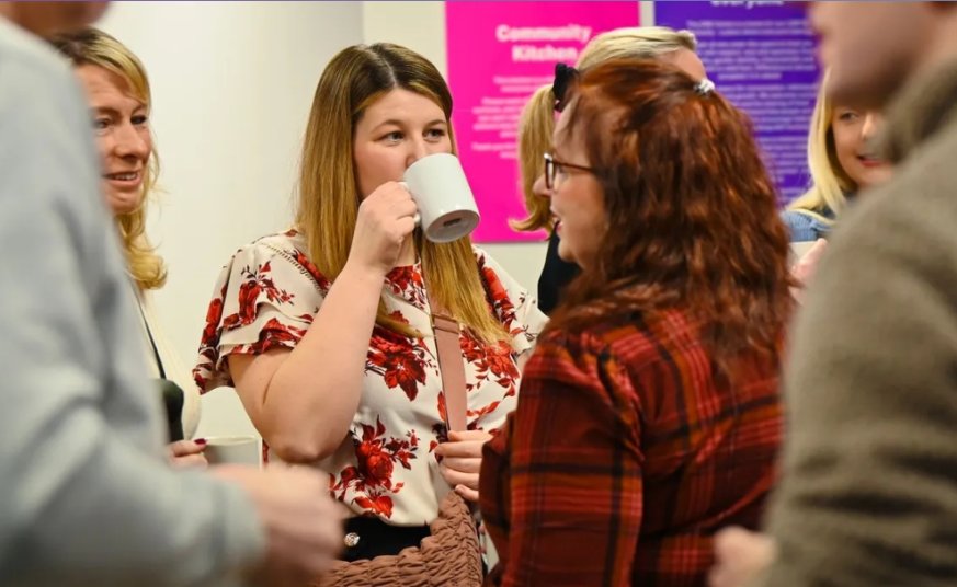 people talking whilst enjoying a mug of tea/coffee 