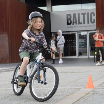 A child is riding a bike and smiling
