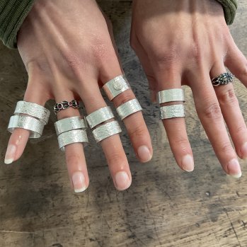 Two Hands showing 10 Silver Rings made in a Ring Making Workshop
