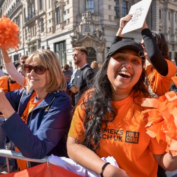 People wearing orange cheering behind barriers