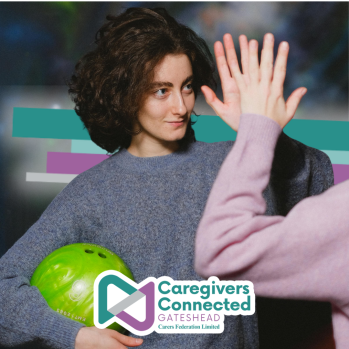 Photograph of a woman giving a high-five during a game of bowling. 