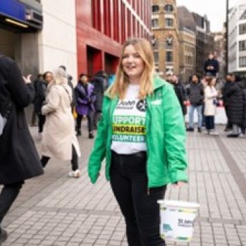 St John volunteer holding a collection bucket in busy town centre