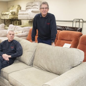 Foundations staff sitting on donated sofas in their charity showroom