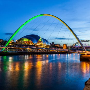 Gateshead Millennium Bridge lit orange and green